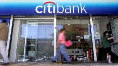 Transeúntes caminan frente a la sucursal de Citibank de San Salvador.