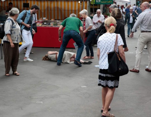 Bystanders give assistance after Les Republicains (LR) party candidate Nathalie Kosciusko-Morizet collapsed following an altercation with a man (R) while campaigning in the 5th arrondissement in Paris on June 15, 2017, ahead of the second round of the French legislative election. / AFP PHOTO / GEOFFROY VAN DER HASSELT