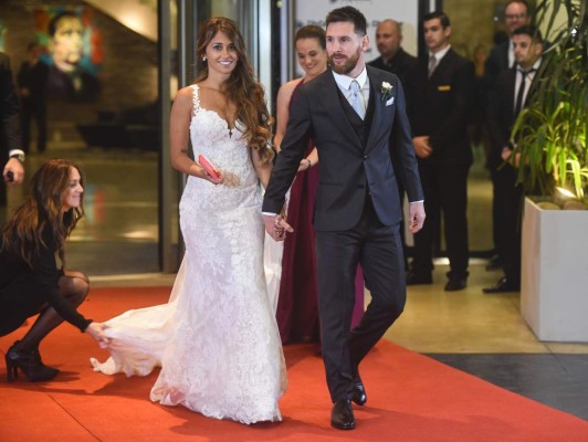 Argentine football star Lionel Messi and bride Antonella Roccuzzo pose for photographers just after their wedding at the City Centre Complex in Rosario, Santa Fe province, Argentina on June 30, 2017.Footballers and celebrities including pop singer Shakira gathered Friday for the 'wedding of the century' in Lionel Messi's Argentine hometown as the Barcelona superstar prepared to marry his childhood sweetheart Antonella Roccuzzo. / AFP PHOTO / EITAN ABRAMOVICH