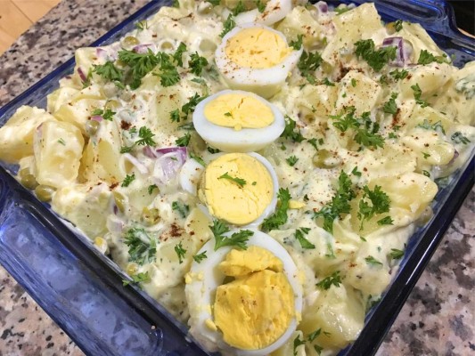 Colocar la ensalada de papas en una bandeja, decorar rodajas de huevo duro, espolvorear con perejil y páprika.