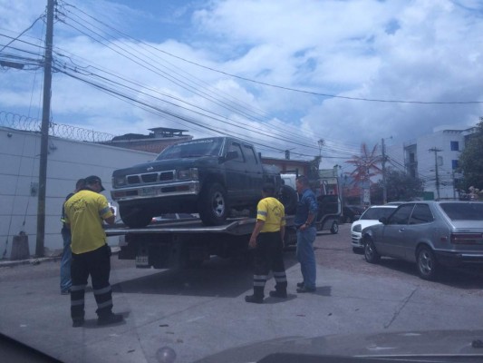 Hondureño indignado sube a su carro para evitar que grúa se lo remolque