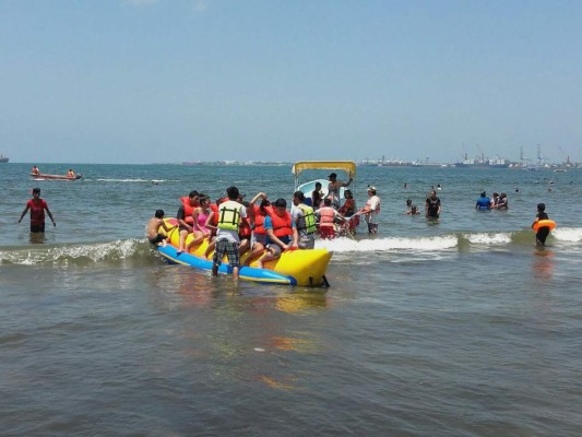 Un grupo de personas disfruta de un flotador artificial en forma de banana en la Playa Municipal de Puerto Cortés, el sábado 26 de marzo, en el marco del feriado de Semana Santa en Honduras.