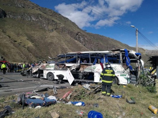Photo released by the Fire Brigade of Quito showing firefighters working at the scene of an accident where a bus crashed into another vehicle, in the road between Pifo and Papallacta, 30 kilometres east of Quito, leaving at least 24 people dead and 20 injured, on August 14, 2018.Venezuelans and Colombians were among the dead, officials said. Traffic accidents are among the leading causes of death in Ecuador. According to the watchdog group Justicia Vial, on average seven people are killed and some 80 people injured each day in traffic accidents. / AFP PHOTO / Fire Brigade of Quito / HO / RESTRICTED TO EDITORIAL USE - MANDATORY CREDIT 'AFP PHOTO - Fire Brigade of Quito' - NO MARKETING NO ADVERTISING CAMPAIGNS - DISTRIBUTED AS A SERVICE TO CLIENTS