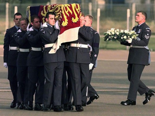 An airman at right holds a family wreath as the coffin containing the body of Diana, Princess of Wales, is carried from an aircraft by airmen of the Royal Air Force, after arriving at Northolt Royal Air Force base from Paris Sunday, Aug. 31, 1997. The Princess, her companion Dodi Fayed, and their driver were killed from injures sustained after their auto crashed in a Paris tunnel while being chased by photographers on motorcyles earlier Sunday. (AP Photo/Lynne Sladky)