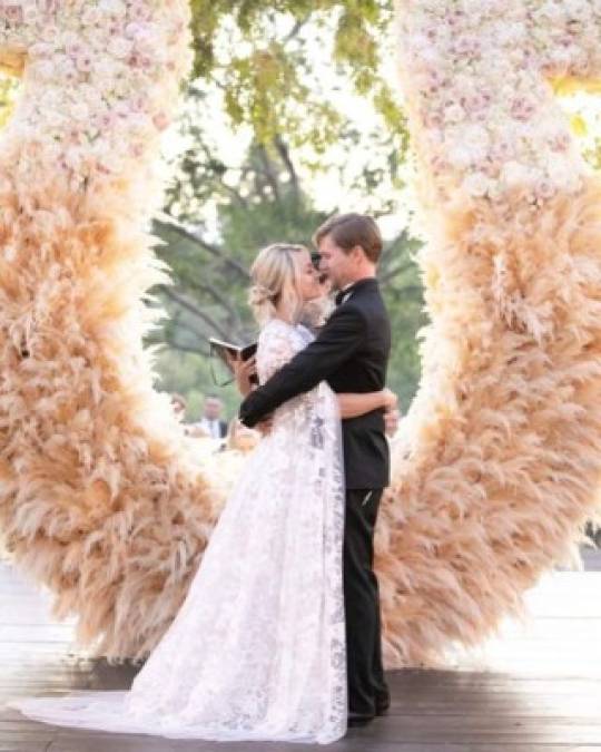 La pareja caminó por los establos antes de llegar al altar e intercambió sus votos frente a un arreglo gigante de flores y plumas en forma de herradura.