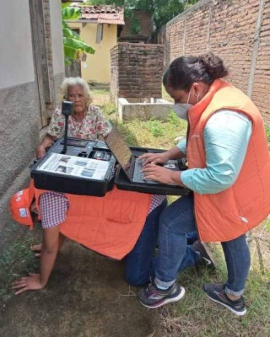 Esta imagen se ha vuelto viral ya que aparece un 'enrolador' siendo una 'mesa humana' para atender a la anciana en un pueblo de Choluteca.