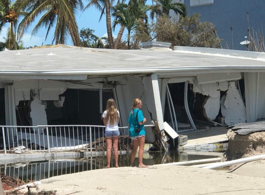 ISLAMORADA, FL - SEPTEMBER 12: Two women look over severe damage to a residence following powerful Hurricane Irma on September 12, 2017 in Isamorada, a village encompassing six of the Florida Keys. Irma made landfall in the Florida Keys as a Category 4 Sunday, swelling waterways an estimated 10 to 15 feet, according to published reports. Marc Serota/Getty Images/AFP== FOR NEWSPAPERS, INTERNET, TELCOS & TELEVISION USE ONLY ==