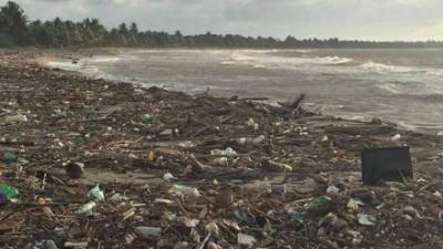 Un niño de la comunidad de Travesía observa los promontorios de basura arrastrados a las playas por las corrientes del río y el mar.