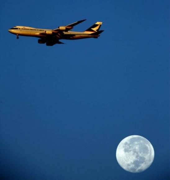 Un avión vuela frente a la super luna en México.