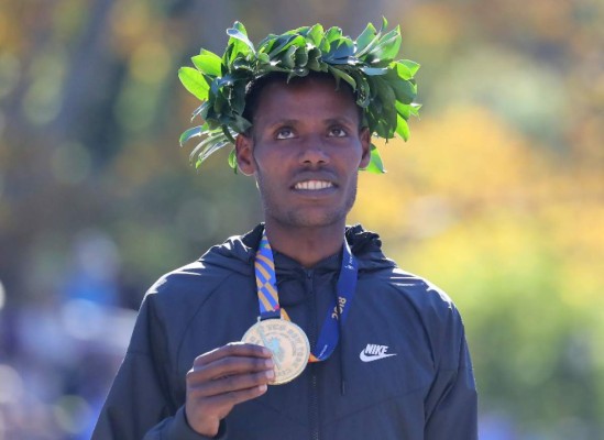 NEW YORK, NY - NOVEMBER 04: Lelisa Desisa of Ethiopia poses with his first place medal at the finish line during the 2018 TCS New York City Marathon on November 4, 2018 in Central Park in New York City. Elsa/Getty Images/AFP