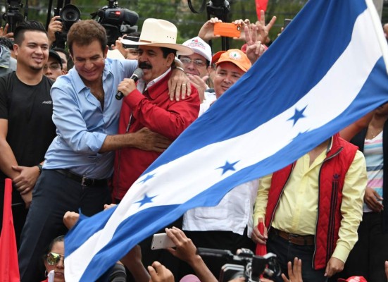 Presidential candidate for the Honduran Opposition Alliance against the Dictatorship, Salvador Nasralla (L) hugs former Honduras' president Manuel Zelaya during a demonstration in front the Supreme Electoral Tribunal (TSE) in Tegucigalpa, on November 27, 2017. Hondurans waited Monday to learn who would be their next president after both leftist TV host-turned-politician Salvador Nasralla and the incumbent Juan Orlando Hernandez claimed victory -- and as the ballot count dragged on. / AFP PHOTO / ORLANDO SIERRA