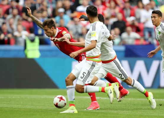 Kazan (Russian Federation), 24/06/2017.- Fedor Smolov (red shirt) of Russia goes down in front of Diego Reyes (foreground) and Nestor Araujo of Mexico during the FIFA Confederations Cup 2017 group A soccer match between Mexico and Russia at the Kazan Arena in Kazan, Russia, 24 June 2017. (Rusia) EFE/EPA/TOLGA BOZOGLU