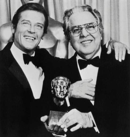 Roger Moore felicita a Albert R. Broccoli, productor de las películas de James Bond, después de que Broccoli recibiera el Erwin Thalberg Memorial Award en las 54as presentaciones anuales del Premio de la Academia en el Hollywood Music Center de Hollywood el 29 de marzo de 1982. AFP