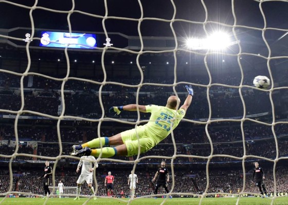 Napoli's goalkeeper from Spain Pepe Reina (C) dives for the ball as Real Madrid's Brazilian midfielder Casemiro scores a goal during the UEFA Champions League round of 16 first leg football match Real Madrid CF vs SSC Napoli at the Santiago Bernabeu stadium in Madrid on February 15, 2017. / AFP PHOTO / JAVIER SORIANO