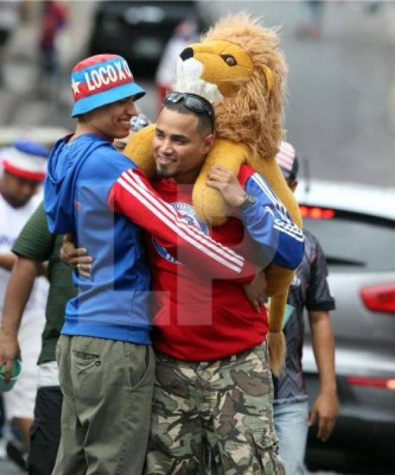 Dos aficionados del Olimpia se encuentran y se abrazan antes de entrar al Nacional.