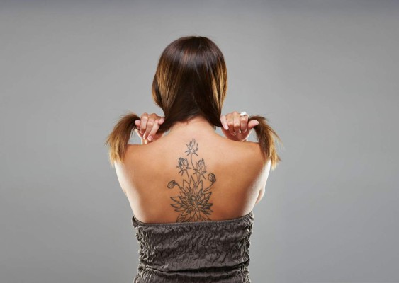 Tattoo woman portrait in studio shoot on grey background