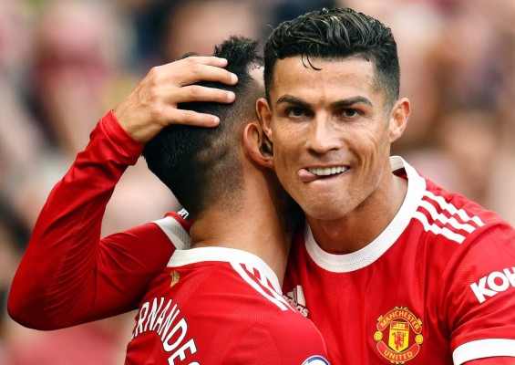 Manchester (United Kingdom), 11/09/2021.- Bruno Fernandes of Manchester United (L) is being congratulated by teammate Cristiano Ronaldo after scoring his team's third goal during the English Premier League soccer match between Manchester United and Newcastle United in Manchester, Britain, 11 September 2021. (Reino Unido) EFE/EPA/PETER POWELL EDITORIAL USE ONLY. No use with unauthorized audio, video, data, fixture lists, club/league logos or 'live' services. Online in-match use limited to 120 images, no video emulation. No use in betting, games or single club/league/player publications