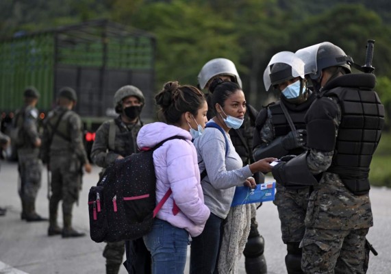 Honduran migrants, part of a US-bound caravan, are intercepted by Guatemalan Army members who ask them for documents in San Luis, Peten department, Guatemala on October 3, 2020. - Over 2.000 Hondurans requested local authorities to return to their country, according to police data sent to journalists. Guatemalan President Alejandro Giammattei on Thursday had ordered the detention of thousands of Hondurans who entered the country as part of a US-bound migrant caravan. (Photo by Johan ORDONEZ / AFP)