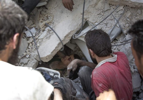 Syrian civil defence volunteers, known as the White Helmets, dig out a young boy trapped under the rubble of destroyed buildings following reported air strikes on the rebel-held neighbourhood of Al-Mashhad in the northern city of Aleppo, on July 25, 2016.Air strikes and barrel bomb attacks killed 16 civilians in rebel-held parts of Aleppo province, with rebel rocket fire onto government areas killing three more, the Britain-based Syrian Observatory for Human Rights said. / AFP PHOTO / KARAM AL-MASRI