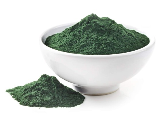 bowl of spirulina algae powder isolated on white