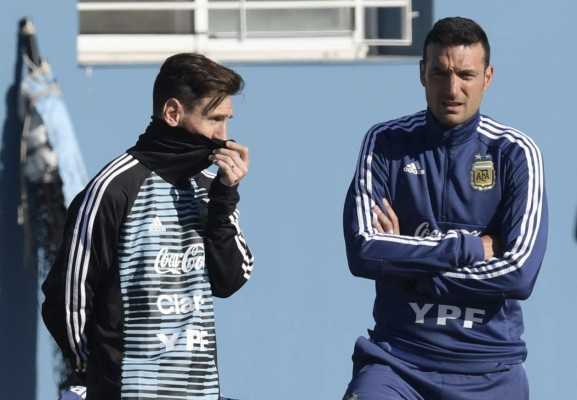 Argentina's forward Lionel Messi (L) and assistant coach Lionel Scaloni gesture during a training session in Ezeiza, Buenos Aires on May 22, 2018, ahead of the Russia 2018 World Cup football tournament. - Argentina's coach Lionel Scaloni called up Lionel Messi to be back in the Argentinian squad on March 7, 2019, ahead of friendly football matches in preparation for the Copa America, to be held in Brazil on June and July 2019. (Photo by JUAN MABROMATA / AFP)