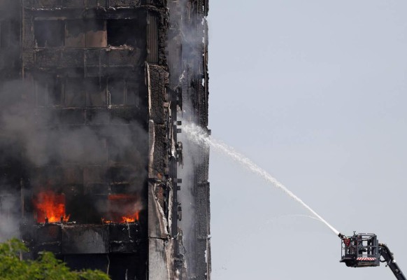 TOPSHOT - Smoke billows from Grenfell Tower as firefighters attempt to control a blaze at a residential block of flats on June 14, 2017 in west London.Shaken survivors of a blaze that ravaged a west London tower block told Wednesday of seeing people trapped or jump to their doom as flames raced towards the building's upper floors and smoke filled the corridors. / AFP PHOTO / Adrian DENNIS