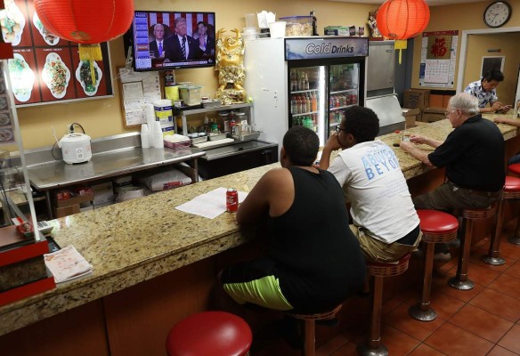 MIAMI, FL - FEBRUARY 28: Christian Morel (L) and Jeremiah Morel (C) watch television at the China Lee restaurant as U.S. President Donald Trump delivers a speech to a joint session of the U.S. Congress on Capitol Hill on February 28, 2017 in Miami, Florida. Trump's first address to Congress focused on national security, tax and regulatory reform, the economy, and healthcare. Joe Raedle/Getty Images/AFP== FOR NEWSPAPERS, INTERNET, TELCOS & TELEVISION USE ONLY ==