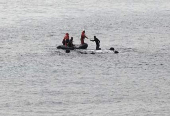 Inmigrante se sube a una roca en el mar, para no ser deportado