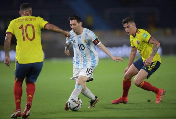 Argentina's Lionel Messi (C), Colombia's Edwin Cardona (L) and Colombia's Mateus Uribe vie for the ball during their South American qualification football match for the FIFA World Cup Qatar 2022 at the Roberto Melendez Metropolitan Stadium in Barranquilla, Colombia, on June 8, 2021. (Photo by Raul ARBOLEDA / AFP)