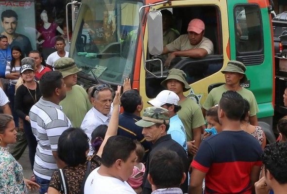 Momento de la discusión entre locatarios y los de la grúa cuando intentaron llevar el carro de Ocatavio Zúniga -lado izquierdo de camisa blanca-.