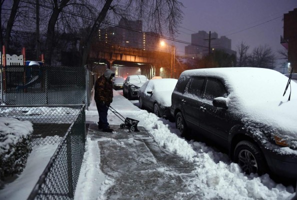 A man plows snow from a sidewalk during a snowstorm in New York on March 14, 2017.Winter Storm Stella unleashed its fury on much of the northeastern United States on Tuesday, dropping snow and sleet across the region and leading to school closures and thousands of flight cancellations. Stella, the most powerful winter storm of the season, was forecast to dump up to two feet (60 centimeters) of snow in New York and whip the area with combined with winds of up to 60 miles per hour (95 kilometers per hour), causing treacherous whiteout conditions. / AFP PHOTO / Jewel SAMAD