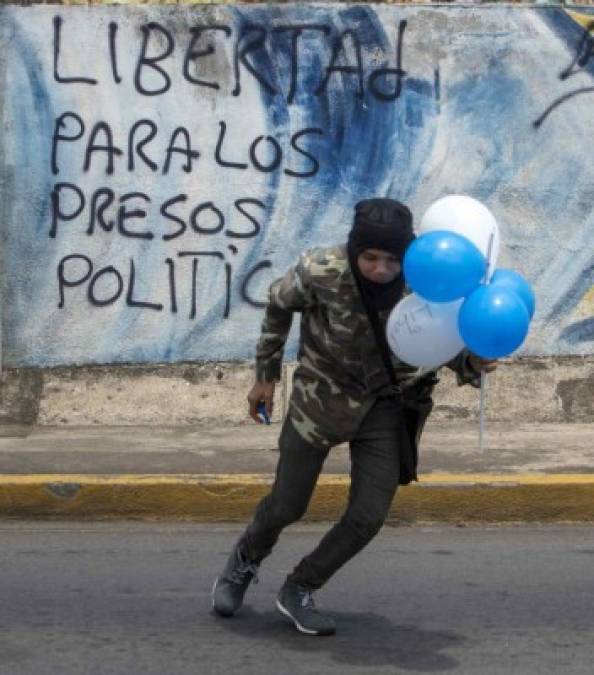 Los opositores avanzaron por las calles levantando globos azules y blancos, el color de la bandera nacional, en los que escribieron su malestar contra el gobierno.