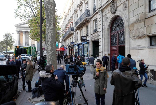 (FILES) This file photo taken at the Rue Tronchet, near Madeleine, central Paris, on October 3, 2016 shows journalists working as police officers stand guard at the entrance to a hotel residence, where US reality television star Kim Kardashian was robbed at gunpoint by assailants disguised as police who made off with millions, mainly in jewellery.16 people were arrested over Kardashian Paris robbery according police source, AFP reported on January 9, 2017. Kardashian was tied up and robbed of jewellery worth around nine million euros ($9.5 million) when a gang of masked men burst into the luxury Paris residence where she was staying during Fashion Week in October. / AFP PHOTO / Thomas SAMSON