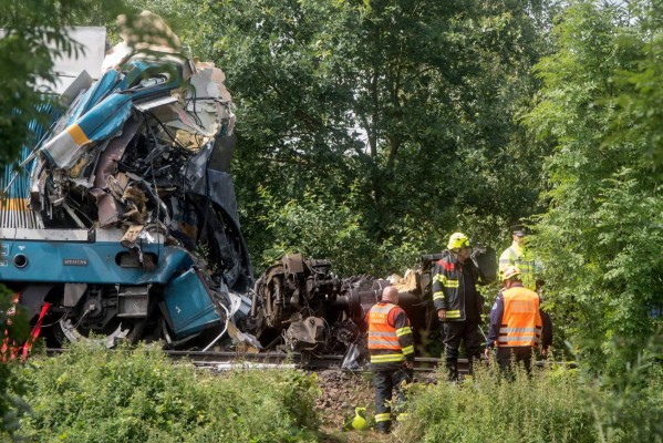 Policemen and firefighters work at the accident site where two trains collided near the village of Milavce between the stations Domazlice and Blizejovn, Czech Republic, on August 4, 2021. - Three people died and dozens more were injured when the Munich-to-Prague train, number Ex 351 belonging to the German firm Die Laenderbahn, collided with a regional service, according to railway officials. (Photo by Michal CIZEK / AFP)