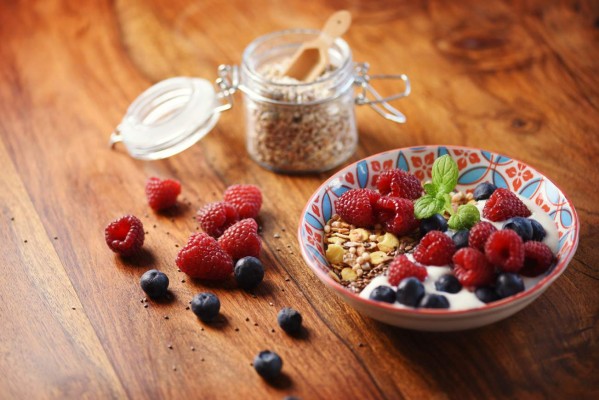 The best start of a new day? Healthy cereals with raspberries, blueberries, flax and chia seeds with soy yoghurt and soy milk topped with a mint leaf - vegan food!