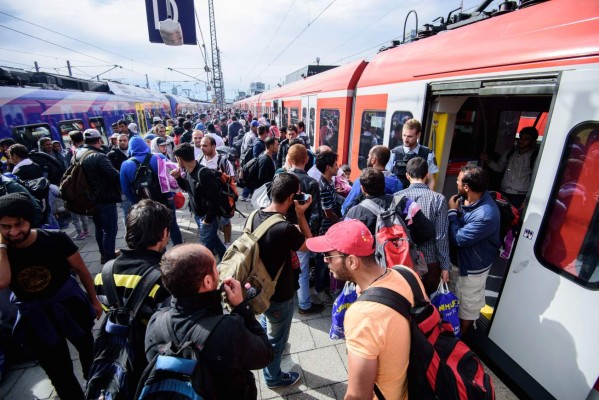 NAR001. Munich (Germany), 13/09/2015.- Refugees are escorted to especially charted trains after they arrived at the main train station in Munich, Germany, 13 September 2015. A total of 12,200 refugees arrived by rail in the southern German city of Munich on 12 September and 4,500 by 13 September evening, Bavarian authorities said. A total of 63,000 had arrived since the end of August. Germany is immediately imposing emergency border controls with Austria to stem the tide of refugees, the interior minister said 13 September, while train service is being halted in both directions. (Alemania) EFE/EPA/NICOLAS ARMER