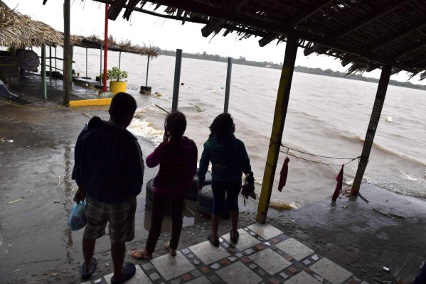 People look out at the Tecolutla River during strong winds and rain before the arrival of Hurricane Katia in Tecolutla, Veracruz state, Mexico on September 8, 2017. Hurricane Katia strengthened to Category Two on the Saffir-Simpson scale of five as it raged towards the eastern coast of Mexico, Mexico's National Water Commission (Conagua) reported. / AFP PHOTO / YURI CORTEZ