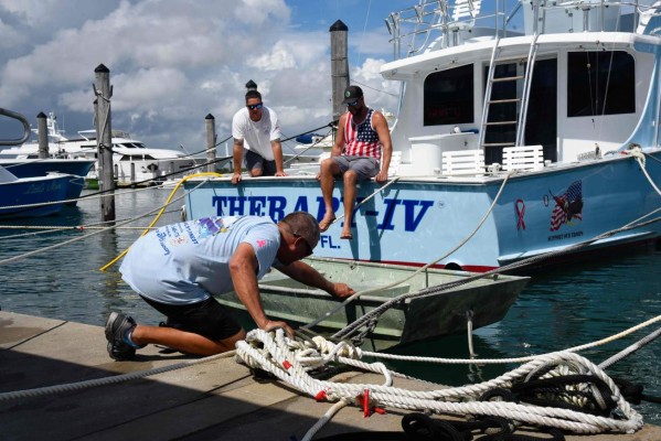 Boat workers Chris Bostwick, Mark and Mike Rodgriguez secure a boat at Haulover Marina in Haulover Beach, Florida, as they prepare for Hurricane Dorian on August 31, 2019. - Hurricane Dorian changed course slightly on Saturday, possibly putting it on track to hit the Carolinas rather than Florida as previously forecast, after a dangerous blast through the Bahamas. Meteorologists said Dorian has grown into an extremely dangerous Category 4 storm as it heads toward land. (Photo by Michele Eve Sandberg / AFP)