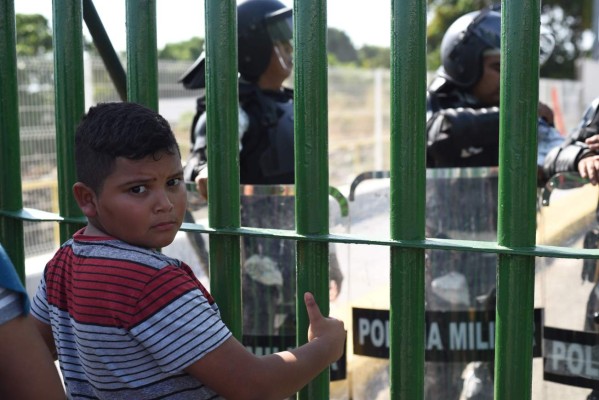 Honduran migrants wait to cross the international border bridge from Ciudad Tecun Uman in Guatemala to Ciudad Hidalgo in Mexico, on January 18, 2020. - On the eve, Mexican President Andres Manuel Lopez Obrador offered 4,000 jobs to members of the caravan in an attempt to dissuade them from traveling on to the United States. The caravan, which formed in Honduras this week, currently has around 3,000 migrants, Lopez Obrador said. (Photo by Johan ORDONEZ / AFP)