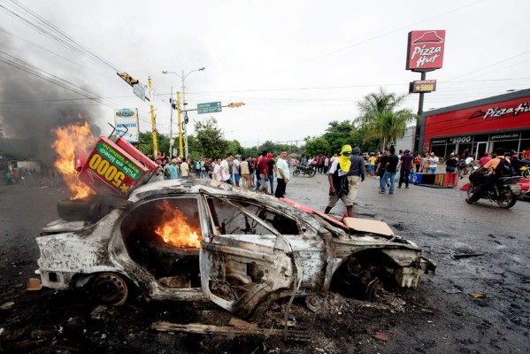 A car set on fire by supporters of Honduran presidential candidate for the Opposition Alliance against the Dictatorship coalition Salvador Nasralla during protests demanding the final results of the weekend's presidential election, burns in Tegucigalpa, on December 1, 2017. Fresh clashes broke out Friday between riot police and opposition supporters in Honduras, as the counting of votes in a cliff-hanging presidential election rolled into a fifth day. Police said at least 12 civilians were injured, some by gunfire, after violence erupted in several parts of the country -- sparked by opposition candidate Salvador Nasralla claiming fraud and calling his supporters onto the streets. / AFP PHOTO / JORDAN PERDOMO