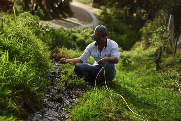 Victor Sandoval, an environmental monitoring technician form the University of San Carlos of Guatemala, collects water samples for analysis, near the Lempa river source in Olopa 213 kilometres east of Guatemala City, on February 3, 2017. Environmental institutions and municipalities from Guatemala, Honduras and El Salvador join efforts to reduce the pollution of the Lempa river, scourged by deforestation, pollution and global warming. / AFP PHOTO / Marvin RECINOS / TO GO WITH AFP STORY BY CARLOS MARIO MARQUEZ