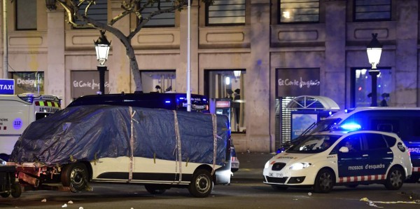 The van who ploughed into the crowd, killing at least 13 people and injuring around 100 others is towed away from the Rambla in Barcelona on August 18, 2017.A driver deliberately rammed a van into a crowd on Barcelona's most popular street on August 17, 2017 killing at least 13 people before fleeing to a nearby bar, police said. Officers in Spain's second-largest city said the ramming on Las Ramblas was a 'terrorist attack'. The driver of a van that mowed into a packed street in Barcelona is still on the run, Spanish police said. / AFP PHOTO / JAVIER SORIANO