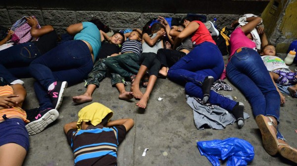 Honduran families sleep in the streets waiting to board a bus leaving the Metropolitan Center of San Pedro Sula, 300 kms north of Tegucigalpa, to travel to the Guatemala border on April 9, 2019. - At least one thousand of Hondurans migrants including women and children were convened by social medias to a new caravan to the US. About four caravans of 2,000 hondurans left San Pedro Sula between October 2018 and January 2019 escaping violence and poverty. (Photo by ORLANDO SIERRA / AFP)