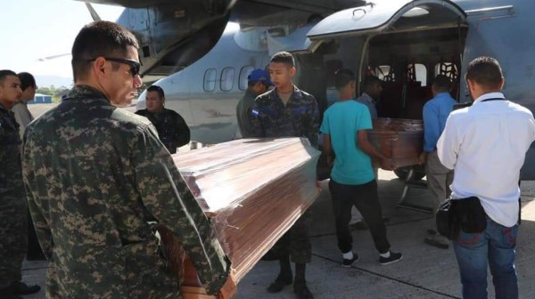 Miembros de las FAH trasladan ataúdes para cuerpos de 27 pescadores fallecidos