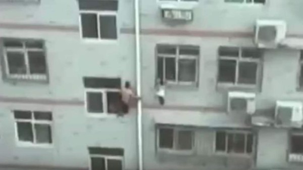Con una escoba, hombre evita caída de niña desde un edificio
