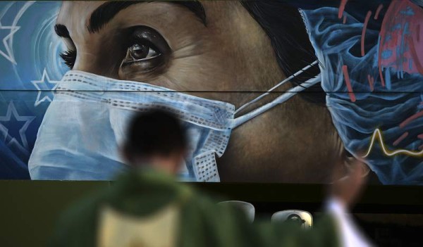 A Catholic priest conducts a mass in memory of the 79 medical doctors and at least 30 nurses, who fought in the first line and were killed by the COVID-19 in Tegucigalpa on February 7, 2021. (Photo by Orlando SIERRA / AFP)