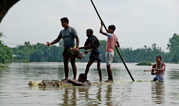 TOPSHOT - Bangladeshi sail on a raft made of banana tree trunks in an area submerged by flood in Kurigram, northern Bangladesh on August 14, 2017. At least 175 people have died and thousands have fled their homes as monsoon floods swept across Nepal, India and Bangladesh, officials said on August 14, warning the toll could rise as the extent of the damage becomes clear. / AFP / STRINGER