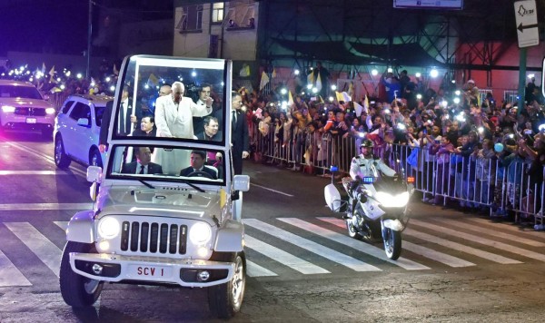 Pope Francis waves from the Popemobile upon his arrival in Mexico City on February 12, 2016. Catholic faithful flocked to the streets of Mexico City to greet Pope Francis on Friday after the pontiff held a historic meeting with the head of the Russian Orthodox Church in Cuba. AFP PHOTO/Yuri Cortez