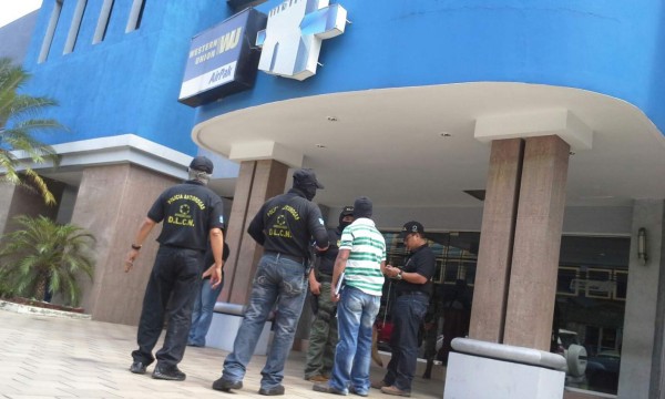 Miembros de la Atic y de la DLCN al momento de llegar al Banco Continental en San Pedro Sula.