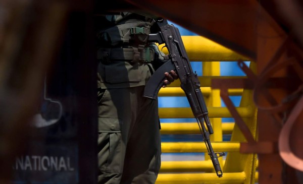 A Venezuelan military officer stands guard as containers block the Tienditas Bridge, which links Tachira, Venezuela, and Cucuta, Colombia, on February 6, 2019. - Venezuelan military officers blocked a bridge on the border with Colombia ahead of an anticipated humanitarian aid shipment, as opposition leader Juan Guaido stepped up his challenge to President Nicolas Maduro's authority. (Photo by Raul Arboleda / AFP)